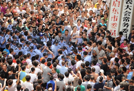 28/7/12 Police beat a protester outside the local government offices in the coastal city of Qidong, near Shanghai, in the eastern China province of Jiangsu. Courtesy Getty Images.