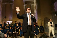 Norman Siegel, wearing the headband of the Williamsburg Warriors, with Reverend Billy and The Church of Stop Shopping Choir at St. Marks Church, March 31, 2005. Ãƒ?Ã‚Â©2005 Fred Askew Photography. All rights reserved.