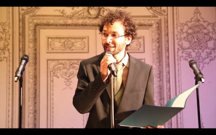 Adam Horowitz as Norman Beckett, USDAC Deputy Secretary, hosting the People’s State of the Union at the Bowery Poetry Club.