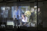 Neïl Beloufa. <em>People’s passion</em>, lifestyle, beautiful wine, gigantic glass towers, all surrounded by water. 2011. Video, 10 min, 59 sec. Installation view: Schinkel Pavilion, <em>Hopes for the Best</em>, April 4 – May 31, 2015. Courtesy the artist, François Ghebaly Gallery, Mendes Wood DM, and ZERO, Milan. Photo: Andreas Rossetti.