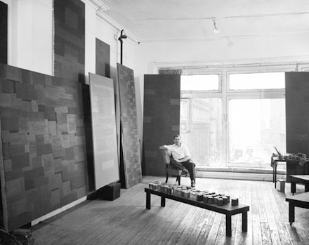 Ad Reinhardt in his studio, 1953. Works on view in the current exhibition include Number 88, 1950 (Blue), 1950, Hirshhorn Museum and Sculpture Garden, Smithsonian Institution, Washington, D.C. (far left); and No. 15, 1952, Albright-Knox Art Gallery, Buffalo (directly to the left of the artist). Photo by Walter Rosenblum. Courtesy David Zwirner, New York/London.