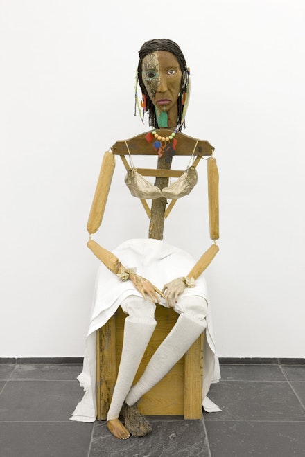 Jimmie Durham, <em>Malinche</em>, 1988-1992. Guava, pine branches, oak, snakeskin, polyester bra soaked in acrylic resin and painted gold, watercolor, cactus leaf, canvas, cotton cloth, metal, rope, feathers, plastic jewelry, and glass eye, 70 x 23 5/8 x 35 in. (177 x 60 x 89 cm.) Stedelijk Museum voor Actuele Kunst (SMAK), Ghent, Belgium