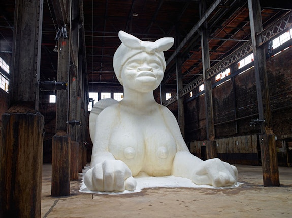 Kara Walker, <em>A Subtlety, or the Marvelous Sugar Baby, an Homage to the unpaid and overworked Artisans who have refined our Sweet tastes from the cane fields to the Kitchens of the New World on the Occasion of the demolition of the Domino Sugar Refining Plant</em>, 2014. Polystyrene foam, sugar, approx. 35.5 x 26 x 75.5 feet. Installation view, Domino Sugar Refinery, A project of Creative Time, Brooklyn, NY, 2014. © 2014 Kara Walker. Photo: Jason Wyche.
