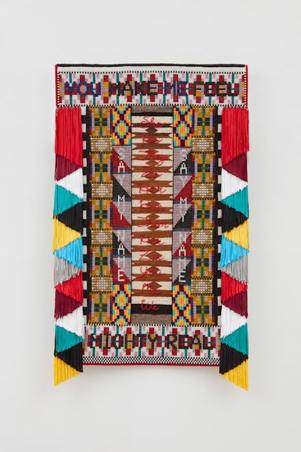 Jeffrey Gibson, <em>SAY MY NAME</em>, 2018. Glass beads, copper and tin jingles, steel and brass studs, and artificial sinew on repurposed trading post weaving and acrylic felt, mounted on canvas, 69 x 41.5 x 3 inches. © Jeffrey Gibson. Courtesy the artist; Sikkema Jenkins & Co., New York; Kavi Gupta, Chicago; and Roberts Projects, Los Angeles.
