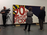 Carol Mancusi-Ungaro interviewing artist Edward Ruscha. Pictured: <em>Large Trademark with Eight Spotlights,</em> 1962, by Edward Ruscha. Oil, house paint, ink, and graphite pencil on canvas, 66 15/16 × 133 1/8 in. (170 × 338.1 cm). Whitney Museum of American Art, New York; purchase with funds from the Mrs. Percy Uris Purchase Fund 85.41. © Ed Ruscha. Photograph by Heather Cox
