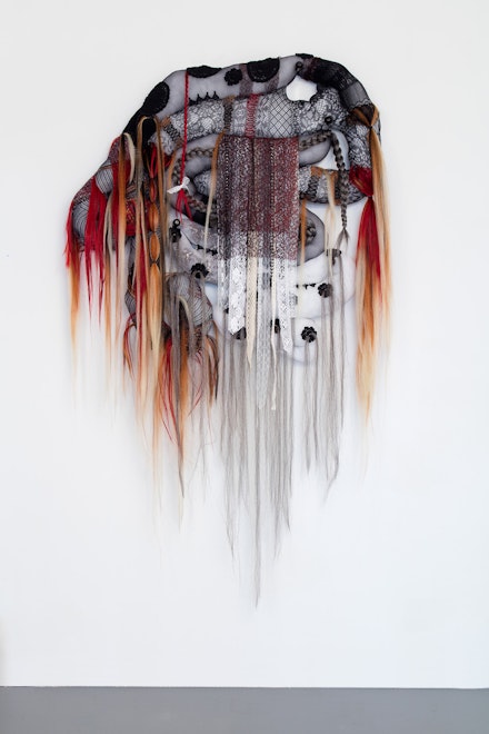 Rina AC Dweck, <em>Sinner II (for Al)</em>, 2019. assorted hosiery, synthetic hair, poly-fil, soil, lace, lace ribbon, macramé decals, thread, rubber bands, beading. 40 x 34 x 4.03 in. Courtesy the artist. 