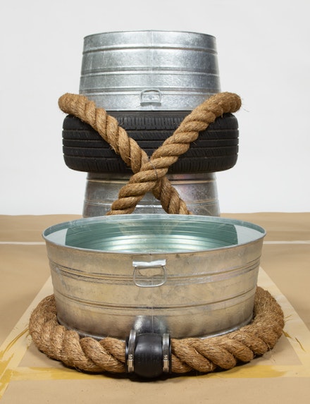 Dorthea Rockburne, <em>Interchange</em>, 2021. Galvanized steel buckets, tire, rope, mirrors, castors, PVC flexible coupling with stainless steel clamps, and water. 36