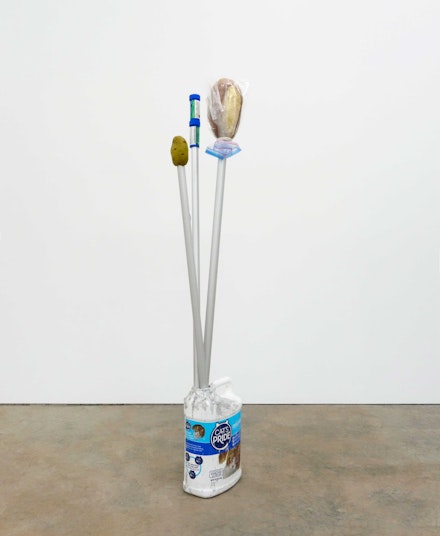 Andrea McGinty, <em>The Good The Bad and The Ugly</em>, 2021. Nicotine lozenge containers, artificial potato, artificial bread, ziploc bag, clothesline, flag poles, cat litter container, pigmented concrete, 53 x 10 x 12 inches. © Andrea McGinty, courtesy SUNNY NY, New York.