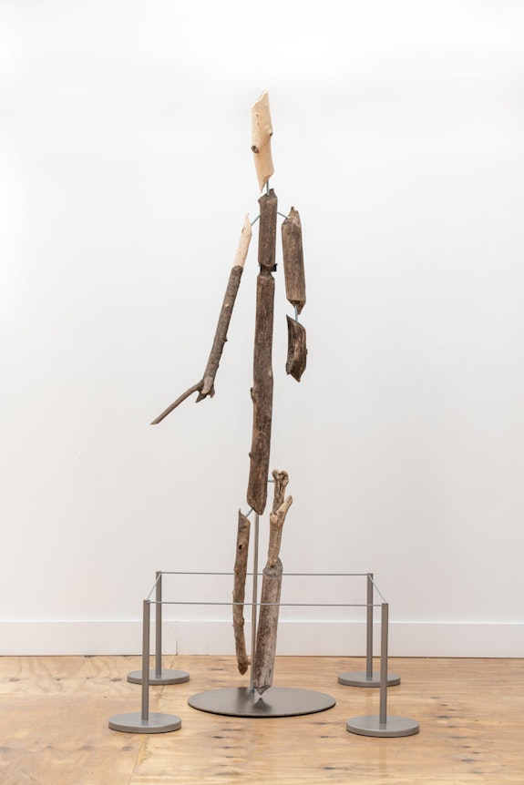 Louis Osmosis, <em>Shtick Figure</em>, 2022. Beaver-chewed wood, threaded rod, steel, epoxy, contact cement, threaded rod, rubber, stanchions. 23 x 32 x 82 inches. Courtesy the artist and Kapp Kapp. Photo: Kunning Huang.