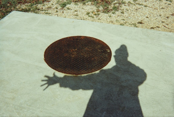 Ray Johnson, <em>shadow and manhole</em>, 1992. Commercially processed chromogenic print, 4 x 6 inches. Courtesy the Ray Johnson Estate.