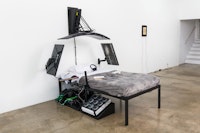 Filip Kostic, <em>Bed PC (Twin)</em>, 2022. Custom built water cooled pc, twin sized bed, 49 inch curved monitor, two 27 inch monitors, mounting hardware, split ergonomic keyboard, mouse, and various hardware, dimensions variable. Courtesy Hunter Shaw Fine Art, Los Angeles. Photo: Ruben Diaz. 