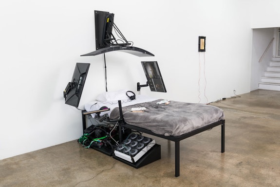 Filip Kostic, <em>Bed PC (Twin)</em>, 2022. Custom built water cooled pc, twin sized bed, 49 inch curved monitor, two 27 inch monitors, mounting hardware, split ergonomic keyboard, mouse, and various hardware, dimensions variable. Courtesy Hunter Shaw Fine Art, Los Angeles. Photo: Ruben Diaz. 