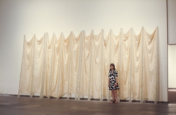 <em>Eva Hesse in front of Expanded Expansion</em>, 1969. Installation view, <em>Anti-Illusion: Procedures/Materials</em>, 1969, Whitney Museum of American Art, New York. Photo courtesy Frances Mulhall Achilles Library, Whitney Museum of American Art, New York.