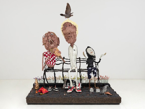 Will Ryman, <em>Give Us A Shot</em>, 2022. Wood, bronze, resin, brass bullets, steel chain, feathers, burlap, paint, taxidermy pigeon, nails, copper wire, polyurethane foam, newspaper clippings, 85 x 74 x 49 inches. Courtesy the artist and Chart Gallery.