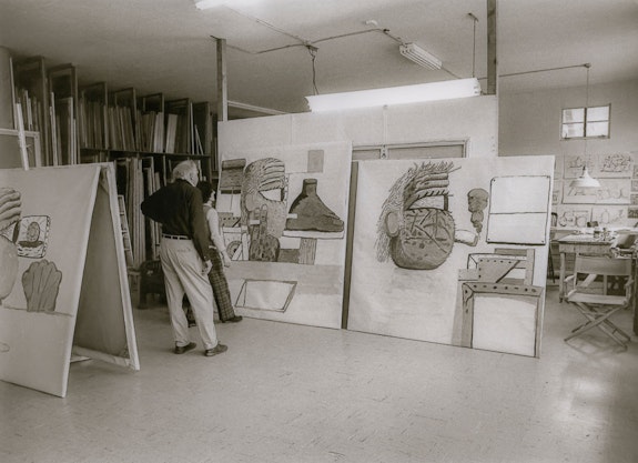 Guston in his studio with Dore Ashton looking at (L-R) <em>Spleen, Painter's Hand</em>, 1975. Photo: Denise Hare