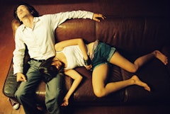 In Last Life in the Universe, Asano on a couch with a woman. Courtesy of Palm Pictures.