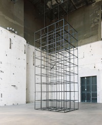 Installation view: <em>Mona Hatoum: all of a quiver</em>, KINDL – Centre for Contemporary Art, Kesselhaus, Berlin, 2022. Aluminium square tubes, steel hinges, electric motor and cable, 339 x 151 1/2 x 114 inches. Courtesy KINDL – Centre for Contemporary Art, Kesselhaus. Photo: Jens Ziehe.