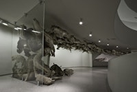 Cai Guo-Qiang, Head On, 2006. 99 life-sized replicas of wolves and glass wall; Wolves: papier mâché, plaster, fiberglass, resin, and painted hide. Dimensions variable. Deutsche Bank Collection, Commissioned by Deutsche Bank AG. Installed at Solomon R. Guggenheim Museum, New York, 2008. © Solomon R. Guggenheim Foundation New York. Photo by David Heald.