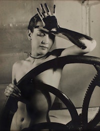 Man Ray, <em>Meret Oppenheim at the Printer’s Wheel (Érotique Voilée)</em>, 1933. Vintage silver print, 11 x 8 3/4 inches. Courtesy Private Collection and Di Donna Galleries.