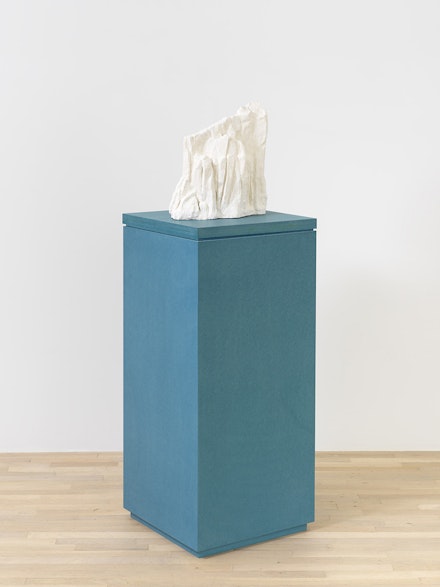 Jennifer Bolande, <em>Drift 3</em>, 2023. Plaster, wood, wire mesh on blue pigmented high-density composite plinth and base, overall: 56 1/2 x 20 x 20 inches, sculpture: 12 x 16 x 6 1/4 inches, plinth: 1 1/2 x 20 x 20 inches, base: 43 x 20 x 20 inches. Courtesy the artist and Magenta Plains, New York. Photo: Object Studies.