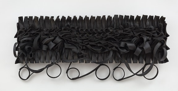 Chakaia Booker, <em>Self Absorbed</em>, 2023. Rubber tires and wood, 43 x 97 1/2 x 7 inches. Courtesy the artist and David Nolan Gallery.
