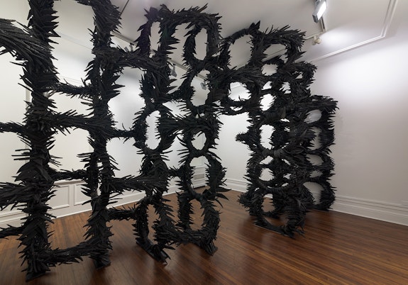 Chakaia Booker, <em>Manipulating Fractions</em>, 2004. (Made in sections) rubber tires, stainless steel, and wood, dimensions variable. Courtesy David Nolan Gallery.