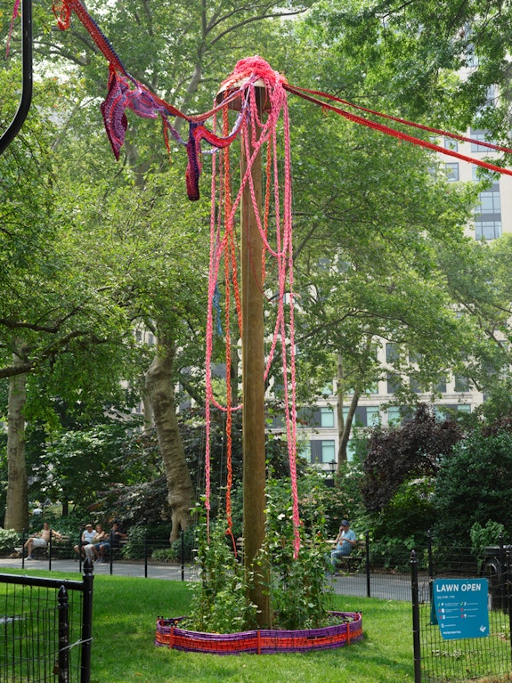 Installation view: <em>Sheila Pepe: My Neighbor’s Garden,</em> Madison Square Park, New York, 2023. Wooden poles, rigging hardware, nylon string, shoelaces, paracord, rubber bands, garden hose, polyester arborist rope, weed-wacker line, plant materials, dimensions variable. © Sheila Pepe. Photo: Elisabeth Bernstein/Madison Square Park Conservancy. 