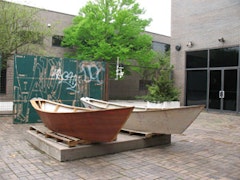 Twi Liberum Dories and four sheets of repurposed and stenciled plywood on display in the courtyard of the Neuberger Museum in Purchase, New York.  Photo by James Trimarco. 
