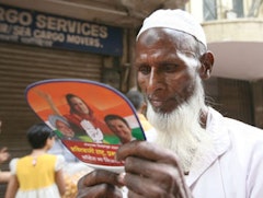 An Indian voter reads a political pamphlet distributed during a rally of the Indian National Congress in the western Indian city of Mumbai. Photo by Al Jazeera English.