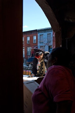 A volunteer peers out the door as a pantry recipient registers to get a bag of food. 