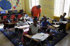 A teacher helps students with classwork at Bed-Stuy’s Children of Promise. Photos by Nick Childers. 