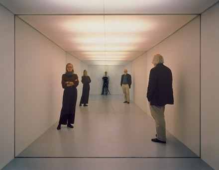 Dan Graham, “Public Space/Two Audiences,” 1976. Two rooms, each with separate entrance divided by thermopane glass, one mirrored wall, muslin, fluorescent lights, wood. Circa 86 2/3 x 275 2/3 x 86 2/3”. Courtesy Marian Goodman Gallery.
